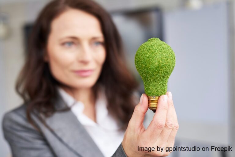 An image of a woman holding a green lightbulb. It represents tips on navigating eco-friendly and vegan fashion.