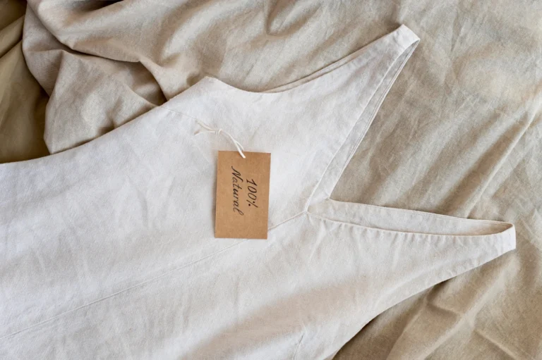 Close-up of a beige linen dress with a '100% Natural' tag, symbolizing sustainable fashion and eco-friendly materials.