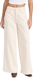 Model wearing Triarchy Women's wide-leg jeans in an off-white wash, featuring a high-rise fit and relaxed silhouette, paired with a cropped white top and brown square-toe heels.